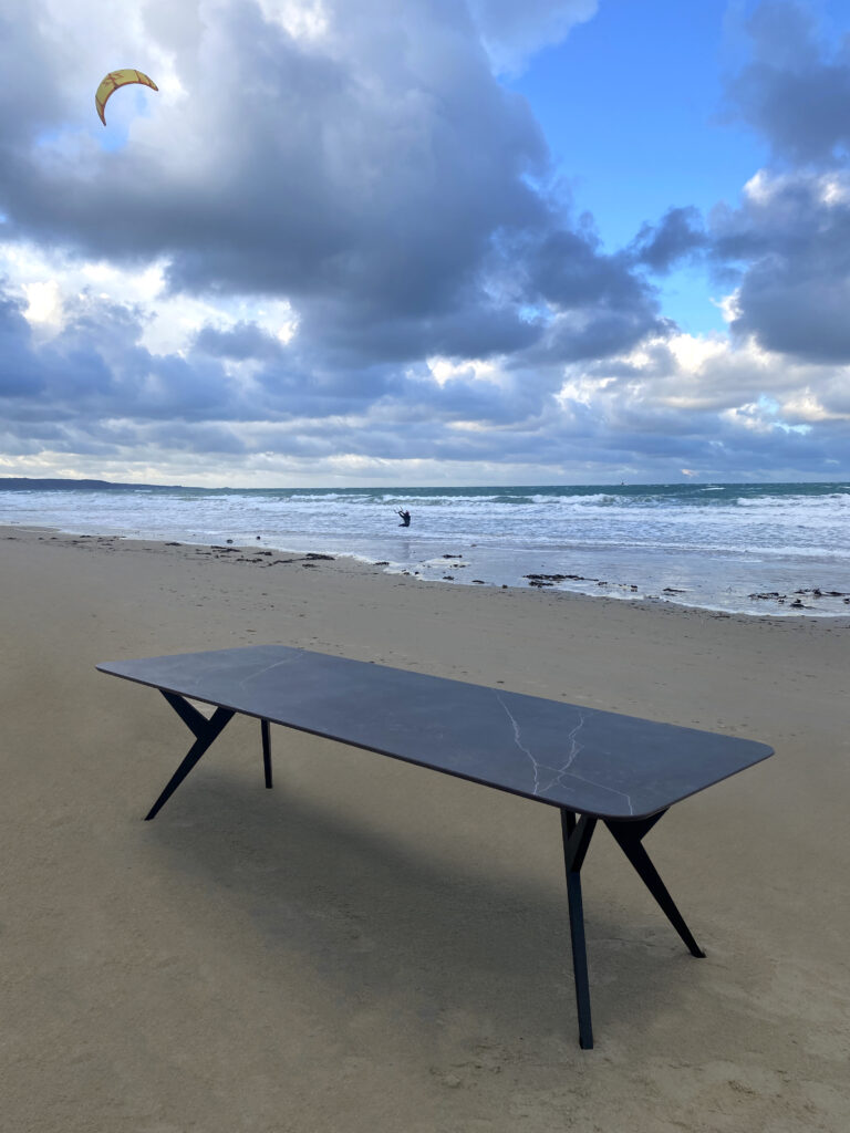 Table extérieure en céramique DEKTON Kelya / Dimensions : 280x100 cm / Photo sur la plage d'Urville-Nacqueville